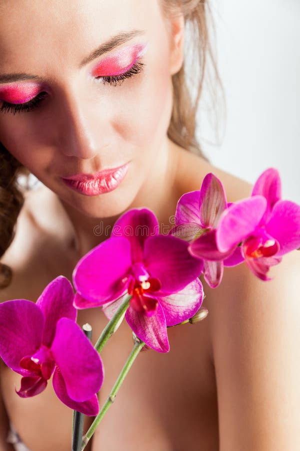Nätt härlig avslappnande kvinna med purpurfärgade orchids royaltyfri bild