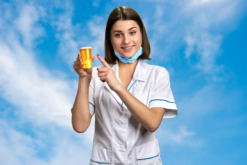 Nätt kvinnlig doktor som pekar på piller royaltyfri bild Nätt kvinnlig doktor som pekar på piller royaltyfri bild