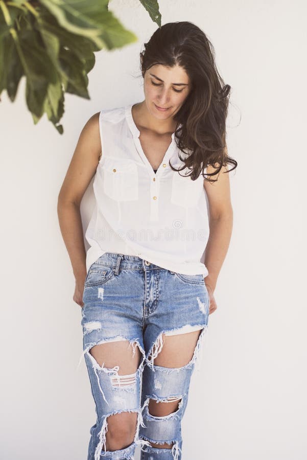 Nätt mogen kvinna med modern stil med bruten jeans arkivfoton Nätt mogen kvinna med modern stil med bruten jeans arkivfoton