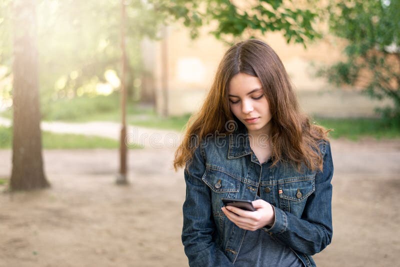 Nätt tonårig flicka som använder telefonen i socialt massmedia royaltyfria bilder Nätt tonårig flicka som använder telefonen i socialt massmedia royaltyfria bilder