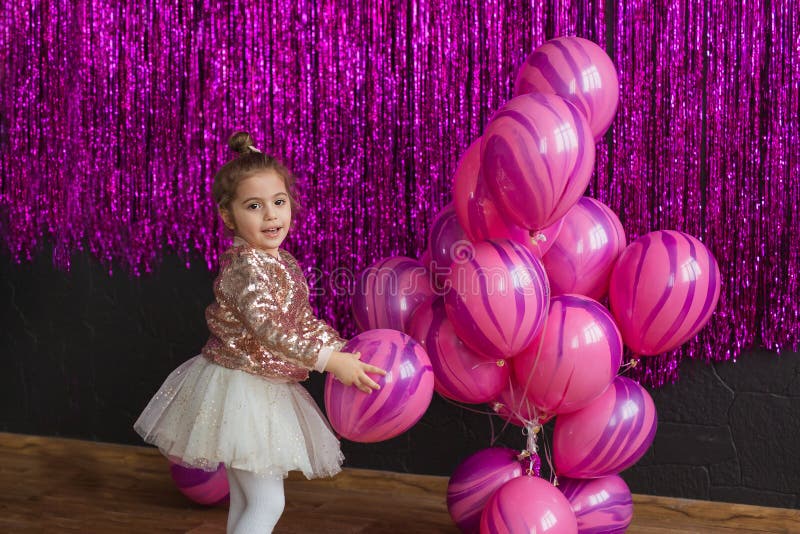Nätta liten flickalekar med rosa ballonger royaltyfria foton Nätta liten flickalekar med rosa ballonger royaltyfria foton