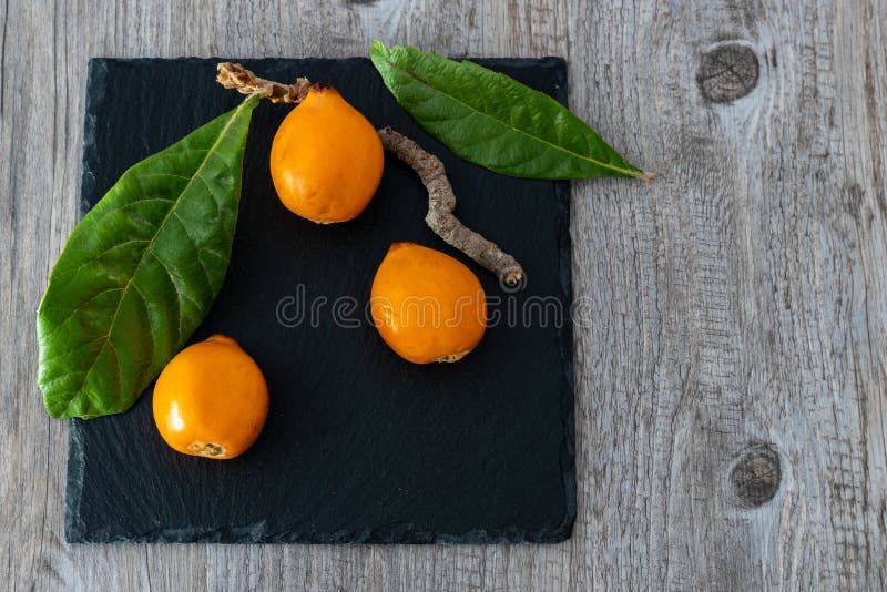 Nísperos con su propio japonica del Eriobotrya de las hojas imagen de archivo Nísperos con su propio japonica del Eriobotrya de las hojas imagen de archivo