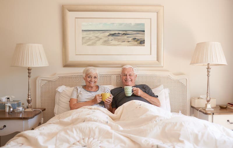 Nöjda höga par som tillsammans dricker kaffe i säng royaltyfri foto Nöjda höga par som tillsammans dricker kaffe i säng royaltyfri foto