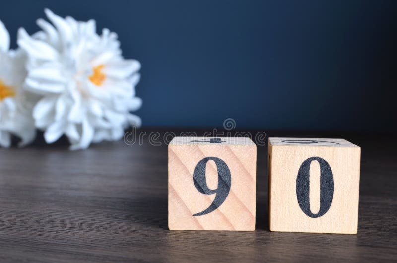 Number 90, rating, award, Empty cover design in natural concept with a number cube and peony flower on wooden table for a background. Number 90, rating, award, Empty cover design in natural concept with a number cube and peony flower on wooden table for a background.