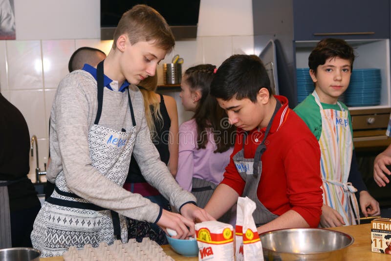 O adolescente caçoa a equipe que cozinha tendo o divertimento imagens de stock O adolescente caçoa a equipe que cozinha tendo o divertimento imagens de stock