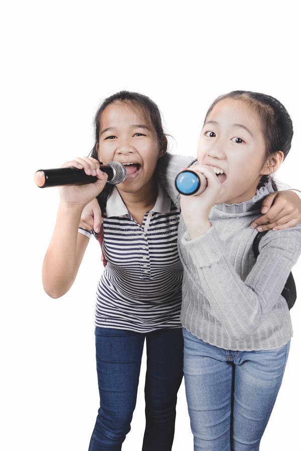 O adolescente dois asi?tico alegre que canta com microfone isolou o fundo branco fotografia de stock O adolescente dois asi?tico alegre que canta com microfone isolou o fundo branco fotografia de stock