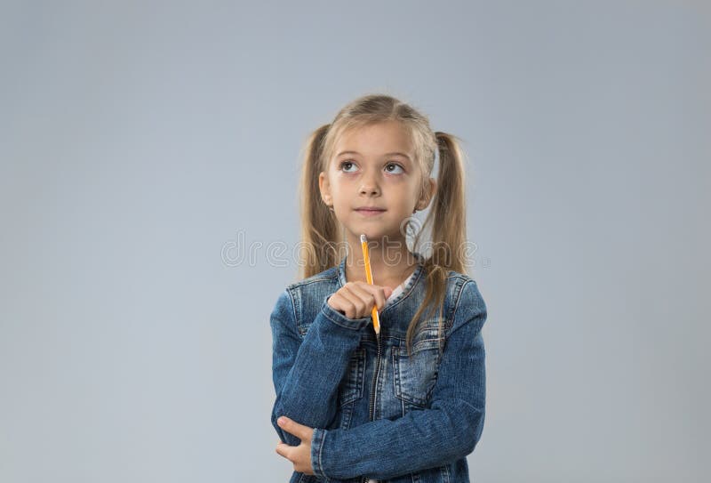O adolescente pequeno no revestimento das calças de brim, criança pequena que olha acima para copiar o espaço pensa a posse Chin foto de stock royalty free O adolescente pequeno no revestimento das calças de brim, criança pequena que olha acima para copiar o espaço pensa a posse Chin foto de stock royalty free