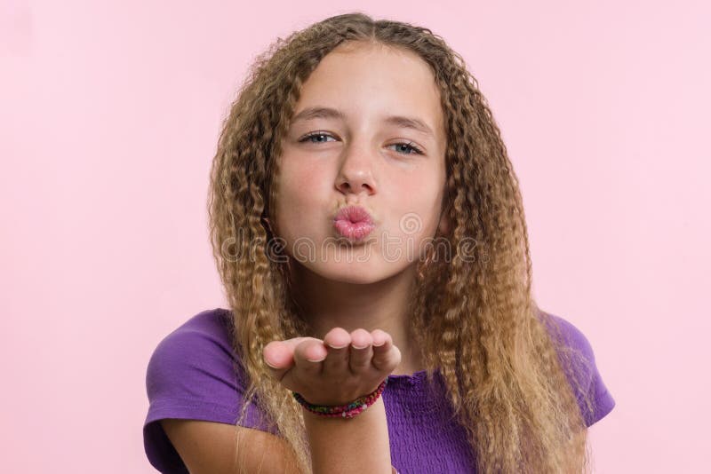 O adolescente positivo atrativo do retrato envia o beijo do ar sobre o fundo cor-de-rosa imagem de stock royalty free O adolescente positivo atrativo do retrato envia o beijo do ar sobre o fundo cor-de-rosa imagem de stock royalty free