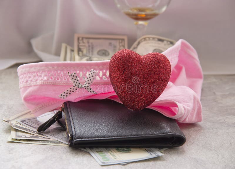O amor para o dinheiro ? prostitui??o Uma folha amarrotada, um vidro do vinho e o dinheiro em seu roupa interior s?o taxas do sex fotos de stock royalty free O amor para o dinheiro ? prostitui??o Uma folha amarrotada, um vidro do vinho e o dinheiro em seu roupa interior s?o taxas do sex fotos de stock royalty free