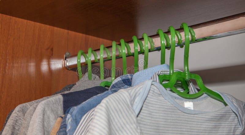 O armário do molho com roupa complementar arranjou em ganchos Vestuário colorido de recém-nascido, crianças, bebês completamente imagem de stock O armário do molho com roupa complementar arranjou em ganchos Vestuário colorido de recém-nascido, crianças, bebês completamente imagem de stock