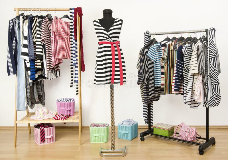 O armário do molho com roupa listrada arranjou em ganchos imagens de stock O armário do molho com roupa listrada arranjou em ganchos imagens de stock