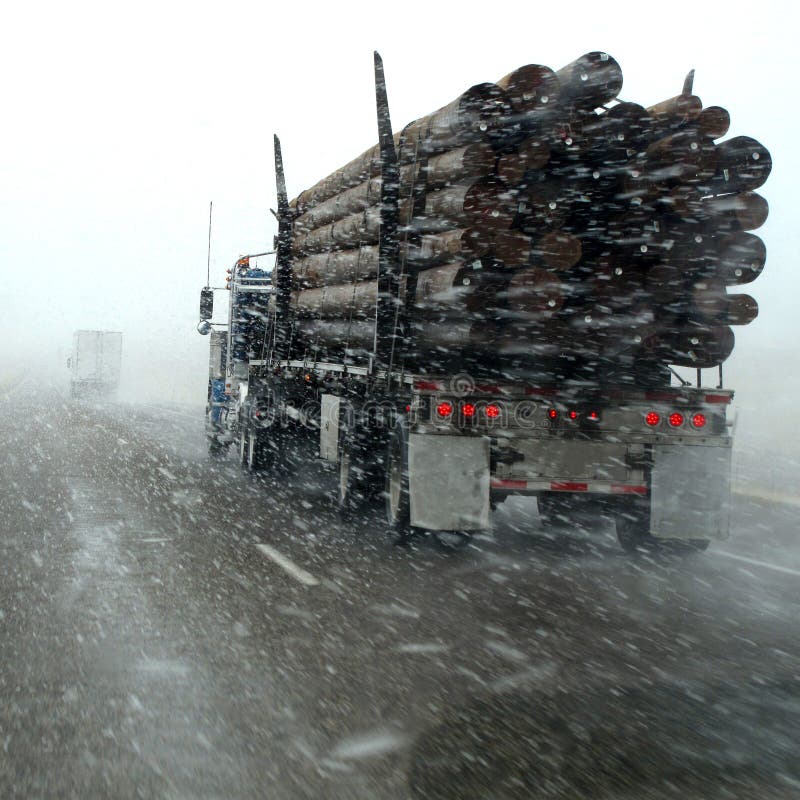 Caminhão a transportar toras em tempestade de inverno fotos de stock