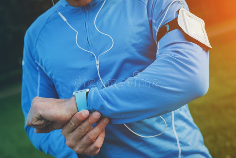 O atleta que verifica o tempo resulta em seu relógio esperto no pulso foto de stock royalty free O atleta que verifica o tempo resulta em seu relógio esperto no pulso foto de stock royalty free