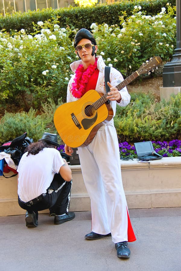 LAS VEGAS, NEVADA, USA - OCTOBER 20, 2013 : Actor dressed as Elvis Presley poses for the camera in Las Vegas, Nevada. Many actors in different costumes entertain tourists in Las Vegas. LAS VEGAS, NEVADA, USA - OCTOBER 20, 2013 : Actor dressed as Elvis Presley poses for the camera in Las Vegas, Nevada. Many actors in different costumes entertain tourists in Las Vegas