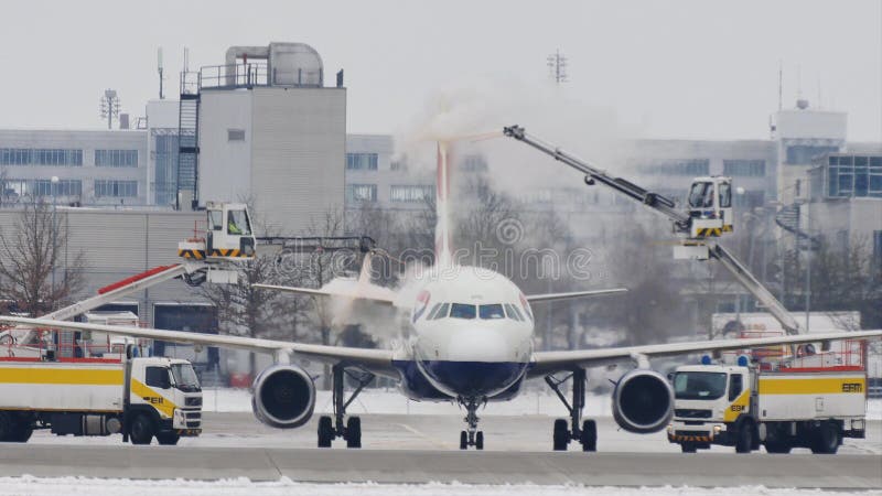 O avião em remove o gelo da almofada, degelando, aeroporto de Munich