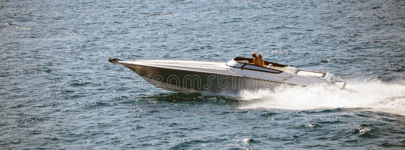O barco de alta velocidade vai rapidamente no mar calmo Os povos apreciam o esporte do verão Vista panorâmica, bandeira fotos de stock O barco de alta velocidade vai rapidamente no mar calmo Os povos apreciam o esporte do verão Vista panorâmica, bandeira fotos de stock
