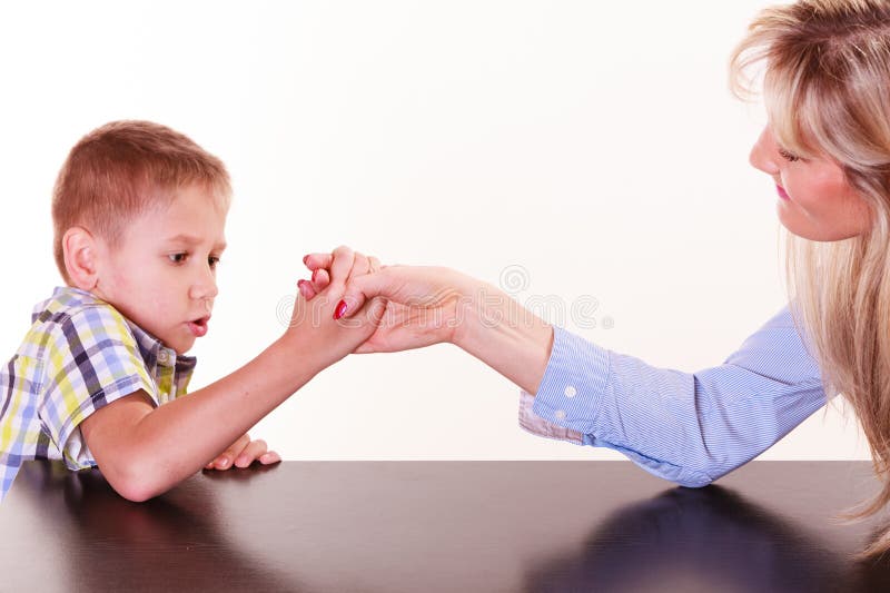 O braço da mãe e do filho atraca-se senta-se na tabela fotos de stock O braço da mãe e do filho atraca-se senta-se na tabela fotos de stock