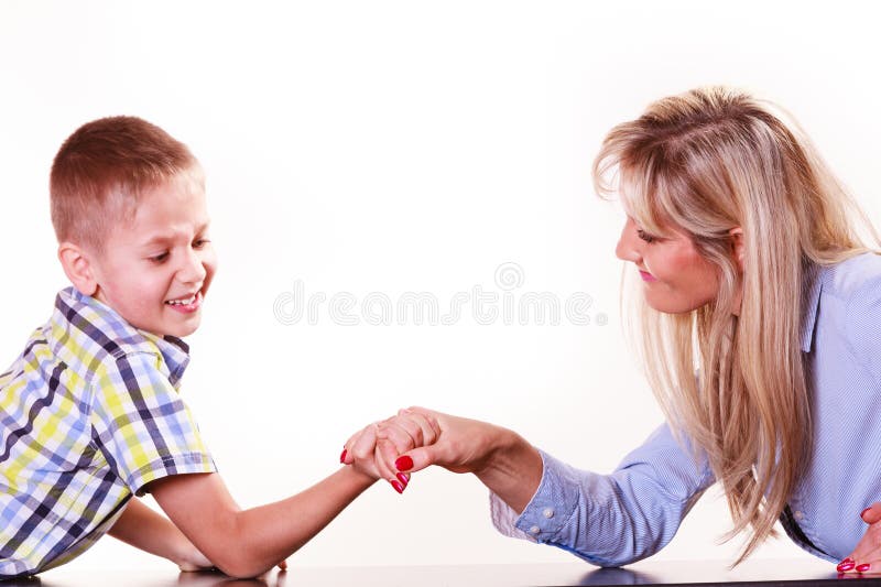 O braço da mãe e do filho atraca-se senta-se na tabela foto de stock royalty free O braço da mãe e do filho atraca-se senta-se na tabela foto de stock royalty free