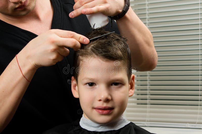 Cabeleireiro de salão de cabeleireiro faz tranças de penteado para bebê  jovem na barbearia mulher de barbeiro faz penteado elegante