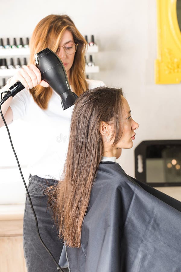 O Cabeleireiro Seca O Cabelo Do Cliente Com Secador De Cabelo E