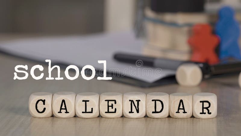 Word SCHOOL CALENDAR composed of wooden dices. Black graduate hat and books in the background. Closeup. Word SCHOOL CALENDAR composed of wooden dices. Black graduate hat and books in the background. Closeup