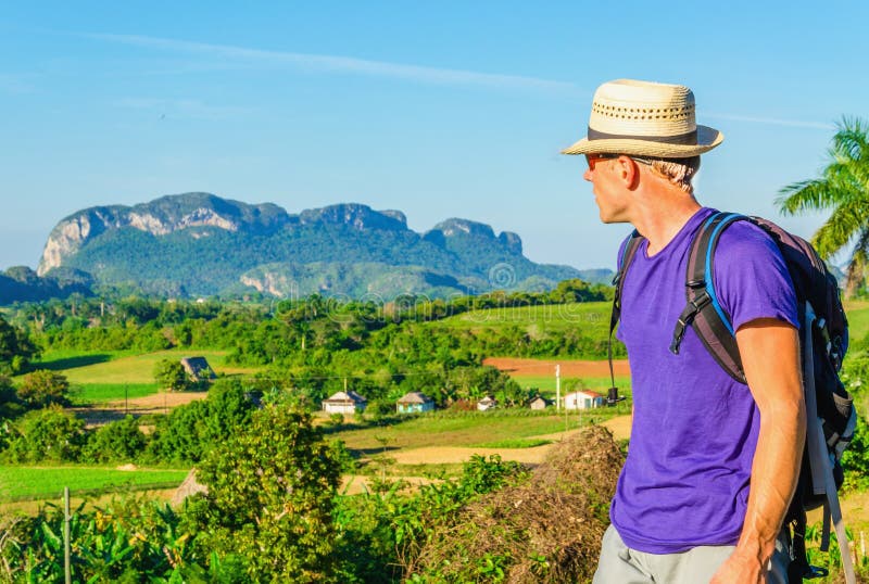 O caminhante novo admira a paisagem em Vinales, Cuba fotografia de stock O caminhante novo admira a paisagem em Vinales, Cuba fotografia de stock