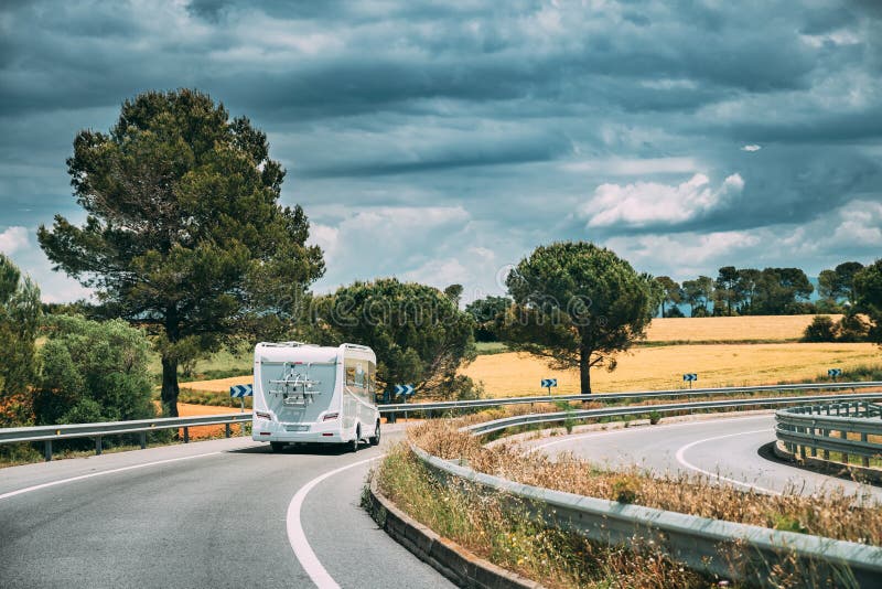 O carro branco de Motorhome da caravana vai na estrada da estrada fotografia de stock royalty free O carro branco de Motorhome da caravana vai na estrada da estrada fotografia de stock royalty free