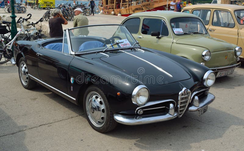 O carro superior aberto preto clássico dos esportes de Alfa Romeo estacionou no stree imagens de stock royalty free O carro superior aberto preto clássico dos esportes de Alfa Romeo estacionou no stree imagens de stock royalty free