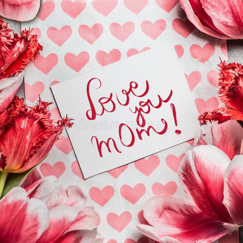 O cartão do dia de mães com tulipas bonitas, corações e ama-o mamã que rotula a vista superior