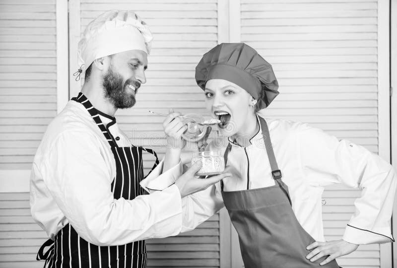 O casal feliz tem a alegria junto na cozinha Ingrediente secreto pela receita Uniforme do cozinheiro Planeamento do menu culinary fotografia de stock royalty free O casal feliz tem a alegria junto na cozinha Ingrediente secreto pela receita Uniforme do cozinheiro Planeamento do menu culinary fotografia de stock royalty free