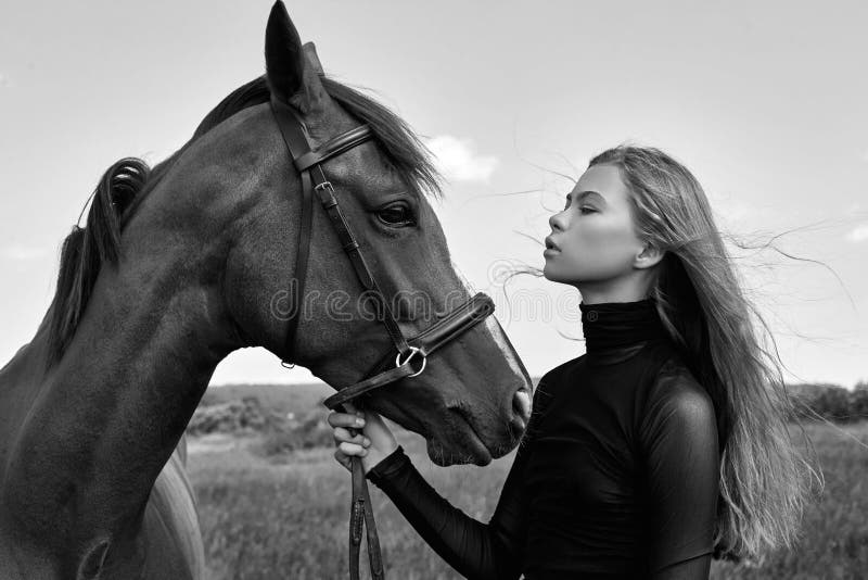 Retrato de camisa xadrez de menina com cavalo preto na fazenda de cavalos.