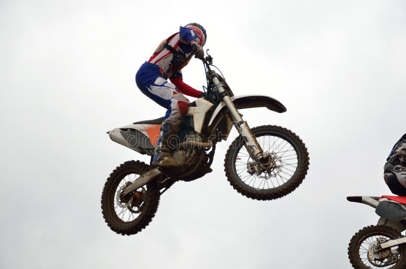 O cavaleiro do motocross voa através do ar foto de stock royalty free O cavaleiro do motocross voa através do ar foto de stock royalty free