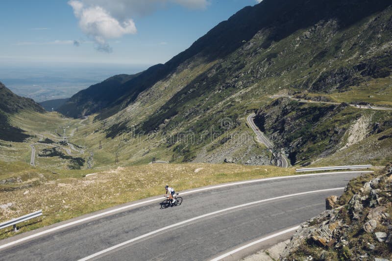 O ciclista profissional monta a estrada de enrolamento fotografia de stock O ciclista profissional monta a estrada de enrolamento fotografia de stock