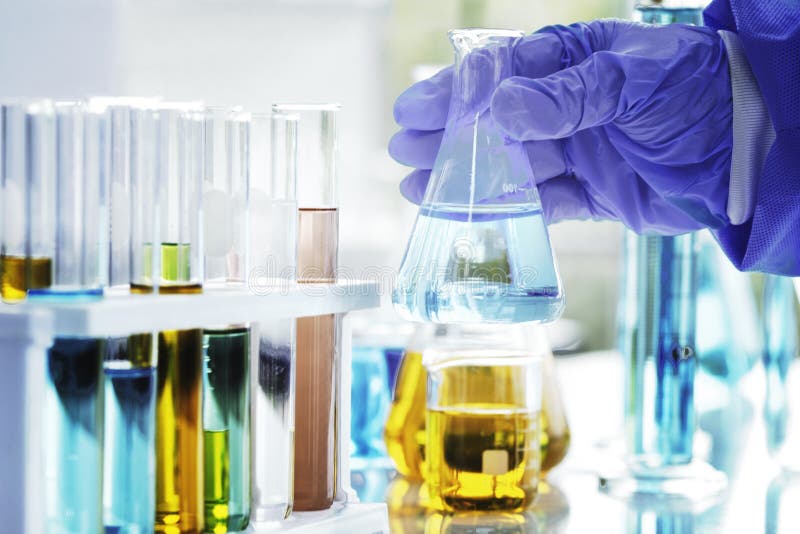 O cientista é mão guarda uma taça dos produtos químicos no laboratório fotos de stock O cientista é mão guarda uma taça dos produtos químicos no laboratório fotos de stock