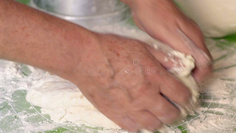 O close-up, as mãos de uma mulher idosa mistura completamente uma massa para a torta