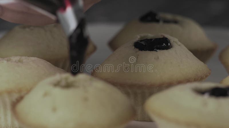 O close-up, as mãos fêmeas enche-se com os queques do doce