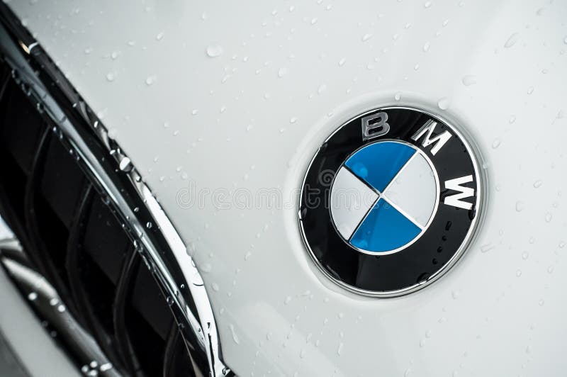 O close up da chuva deixa cair na parte dianteira branca do carro de BMW fotografia de stock O close up da chuva deixa cair na parte dianteira branca do carro de BMW fotografia de stock