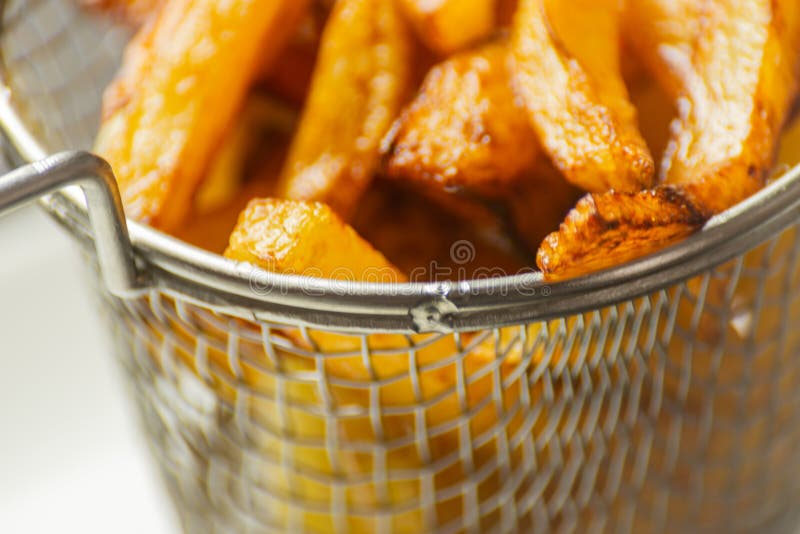 O close up de fritadas douradas preparou-se das batatas frescas, gordurosas mas imagem de stock O close up de fritadas douradas preparou-se das batatas frescas, gordurosas mas imagem de stock