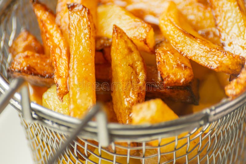 O close up de fritadas douradas preparou-se das batatas frescas, gordurosas mas foto de stock royalty free O close up de fritadas douradas preparou-se das batatas frescas, gordurosas mas foto de stock royalty free