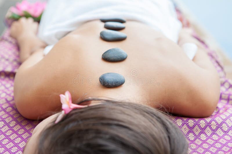 O close up na jovem mulher que tem a massagem de pedra quente suporta sobre nos termas foto de stock royalty free O close up na jovem mulher que tem a massagem de pedra quente suporta sobre nos termas foto de stock royalty free
