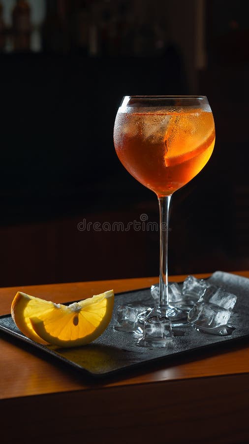O cocktail Aperol da bebida fresca Spritz com fatias e gelo alaranjados na bandeja preta fotografia de stock royalty free O cocktail Aperol da bebida fresca Spritz com fatias e gelo alaranjados na bandeja preta fotografia de stock royalty free