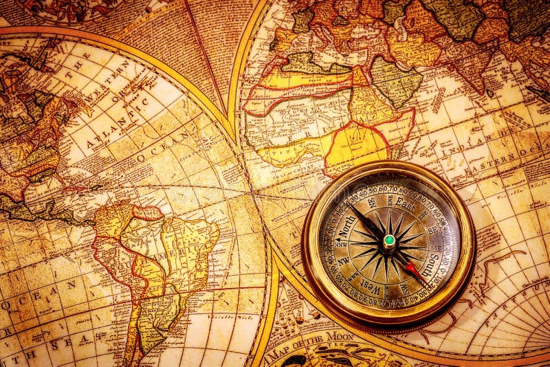 O compasso do vintage encontra-se em um mapa do mundo antigo.