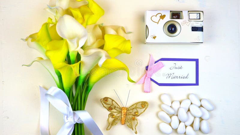 O conceito do casamento em cima encontrou-se horizontalmente com ramalhete, câmera, e as amêndoas doces imagem de stock royalty free O conceito do casamento em cima encontrou-se horizontalmente com ramalhete, câmera, e as amêndoas doces imagem de stock royalty free