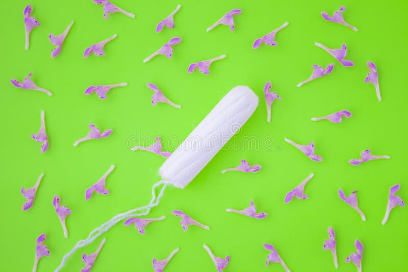 O conceito do ciclo menstrual, da menstrua??o e dos produtos ?ntimos com um cotonete interno, no fundo verde com espa?o da c?pia imagem de stock royalty free O conceito do ciclo menstrual, da menstrua??o e dos produtos ?ntimos com um cotonete interno, no fundo verde com espa?o da c?pia imagem de stock royalty free