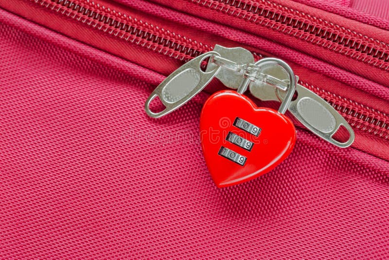 Closeup top view of red heart shaped lock with code locking fabric suitcase luggage. Closeup top view of red heart shaped lock with code locking fabric suitcase luggage