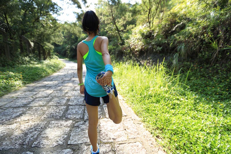 O corredor da fuga da mulher aquece-se na estrada secundária fotos de stock O corredor da fuga da mulher aquece-se na estrada secundária fotos de stock