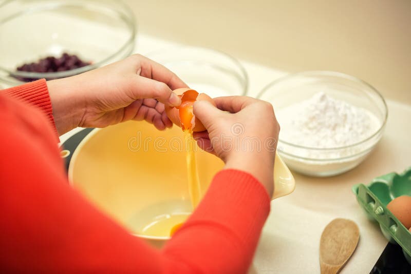 O cozinheiro adiciona a mistura do ovo para bolos imagens de stock royalty free O cozinheiro adiciona a mistura do ovo para bolos imagens de stock royalty free