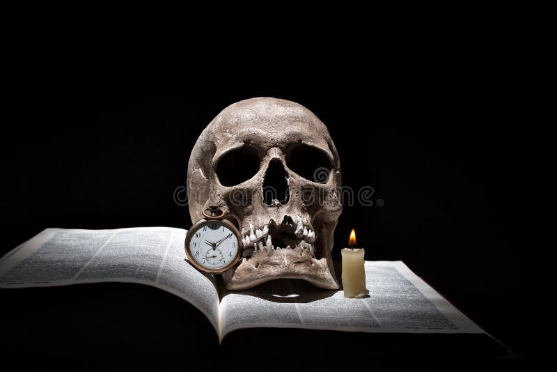 O crânio humano no livro aberto velho com vela ardente e o vintage cronometram no fundo preto sob o feixe de luz foto de stock O crânio humano no livro aberto velho com vela ardente e o vintage cronometram no fundo preto sob o feixe de luz foto de stock
