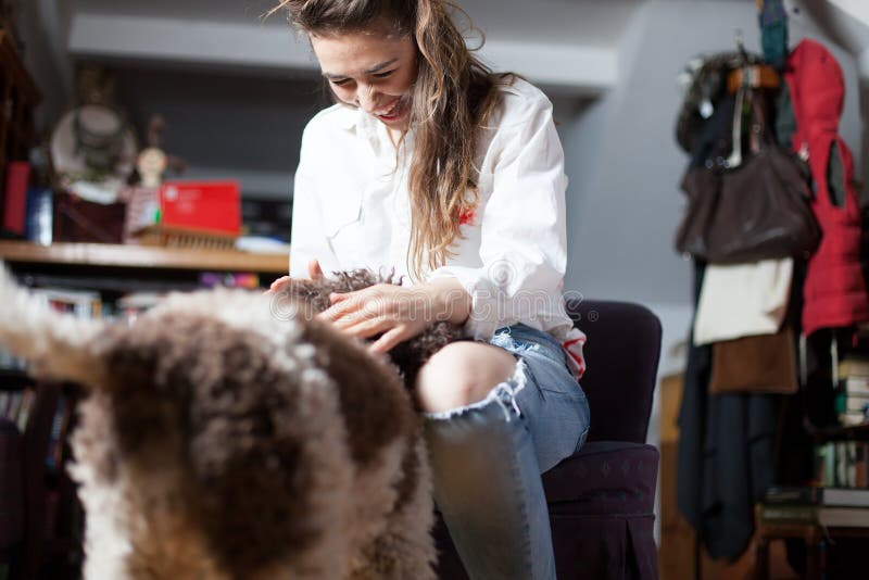 O cão dá boas-vindas à mulher após ter retornado a casa imagens de stock O cão dá boas-vindas à mulher após ter retornado a casa imagens de stock