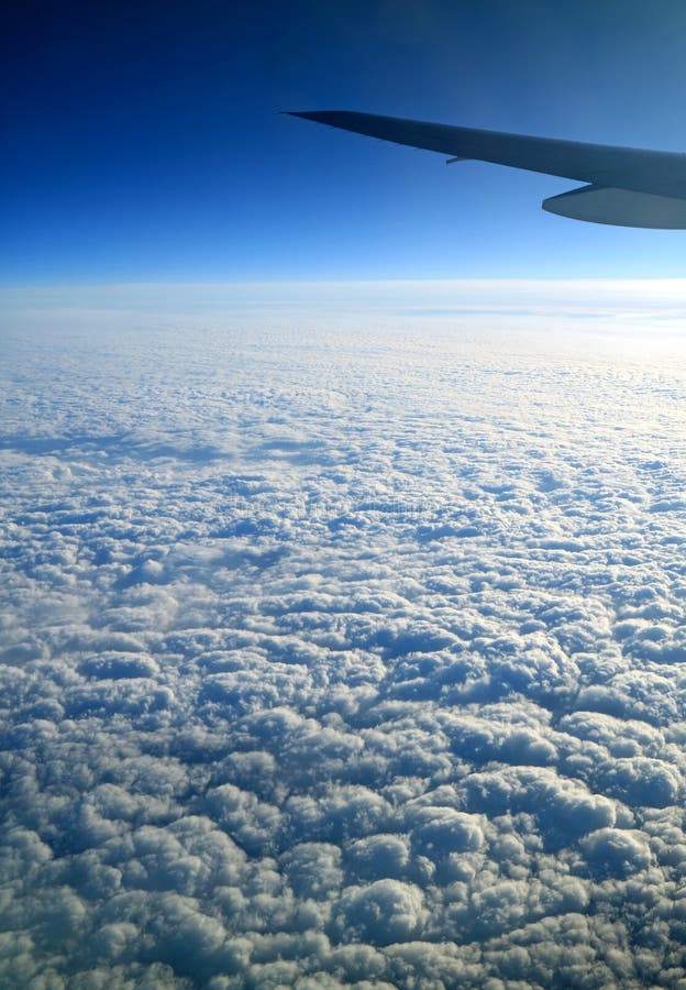 O céu azul profundo e as nuvens brancas puras com avião voam visto da janela plana durante o voo fotografia de stock royalty free O céu azul profundo e as nuvens brancas puras com avião voam visto da janela plana durante o voo fotografia de stock royalty free